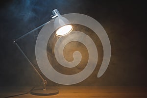 Desk lamp in smoke, copy-space background