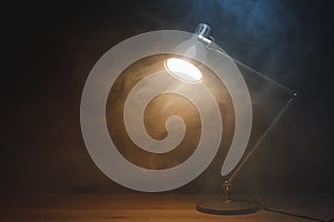 Desk lamp in smoke, copy-space background