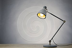 Desk lamp on the table, gray background with copy-space