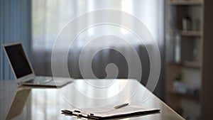 Desk with laptop and contract, empty workplace at company office, business