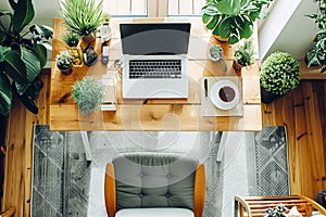 A desk with a laptop, a cup of coffee, and a plant