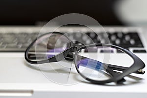 Desk with laptop, glasses and other items