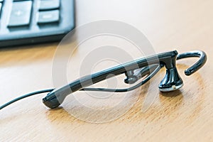 On the Desk lies wired headset and in the background lies the calculator.