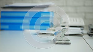 Desk Office Image with Archived Documents and a Paper Hole Puncher on Table