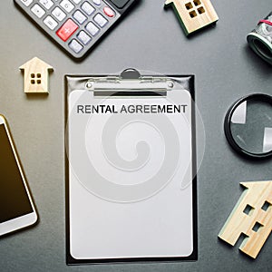 Desk real estate agent and tablet with the word Rental Agreement. The concept of a successful rental house or apartment. Property