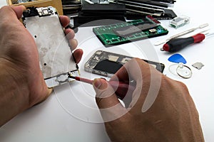 On the desk Repairman Preparing to change home button à¸ºButton of the mobile phone has been damaged.