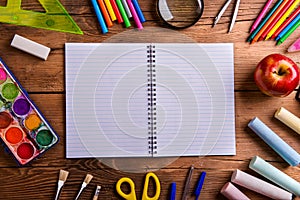 Desk, school supplies, lined paper, wooden background, copy space