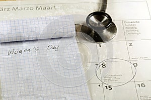 Desk with stethoscope, calendar and notebook. Women`s day concept.