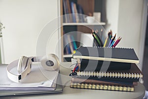 Desk for student education concept. Book, and pencil for study for exam. Laptop and headphone placed on white School table with