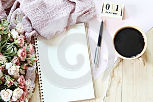 Desk table with scarf, notebook paper, cube calendar and coffee cup