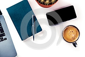 Desk, top view on a white background. Coffee, notebook, phone, plant