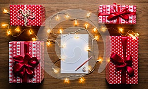 Desk view from above with letter to santa, presents and christmas lights, retro xmas concept