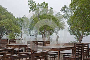 Desks in an empty cafÃ© on a misty shore