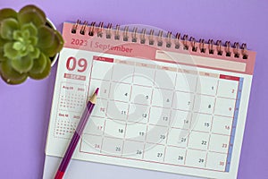 Desktop calendar for September 2023 on a lilac background.
