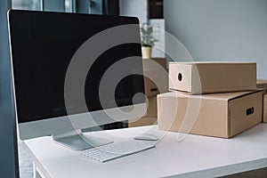 desktop computer with blank screen and cardboard boxes at workplace