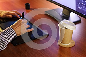 Desktop with computer, graphics tablet and a cup of coffee