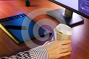 Desktop with computer, graphics tablet and a cup of coffee