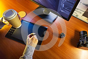 Desktop with computer, graphics tablet and a cup of coffee