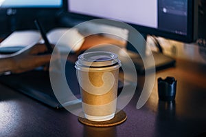 Desktop with computer, graphics tablet and a cup of coffee. Side view