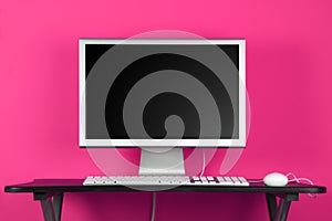 Desktop computer and pink wall