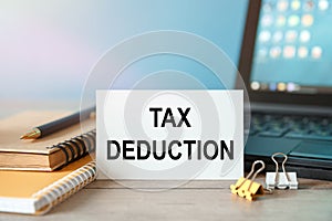 Desktop with documents, calculator and notebook. Inscription TAX DEDUCTION