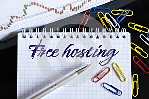 On the desktop are a forex chart, paper clips, a pen and a notebook in which it is written - Free hosting