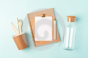 Desktop mockup planner. Flat lay of blue mint table background . Top view glass jar, coffee cup, cutlery, blank, craft