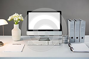 Desktop pc with flower vase and files photo