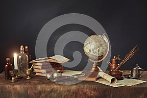 Desktop of a scientist, writer, or student of past centuries. Vintage items, books and manuscripts on a dark background