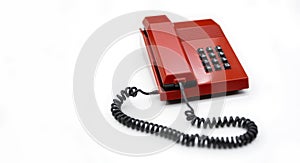 Desktop telephone from the 80`s and red color isolated on a white background. Space for text