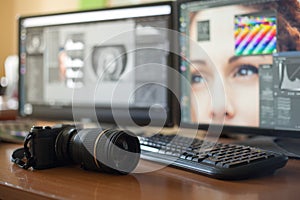 Desktop with two monitors, a keyboard, a camera, a diary, a palette for a designer, a retoucher, a photographer.