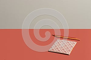 Desktop in vivid coral notebook with Renaissance pattern in live coral background