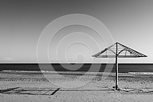 Desolate beach with parasol by the sea