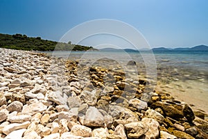 A desolated pebble beach on the Adriatic Sea near the city of Dubvronik. The water is crystal clear with a turquoise color