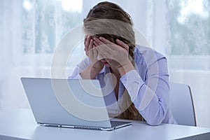 Despair cyberbullying victim covering eyes