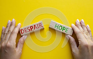 Despair or Hope symbol. Concept word Despair or Hope on wooden blocks. Businessman hand. Beautiful yellow background. Business and