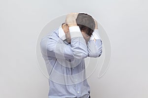 Despair sad upset man standing and hiding his face with hand, having problems avoids very loud noise