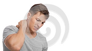 Despaired attractive millennial european muscular male suffer from neck pain, presses hand to sore spot