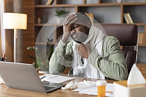 Despaired unhappy middle aged black businessman in scarf suffer from sore throat and high temperature