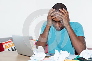 Desperate african american man at desktop at home