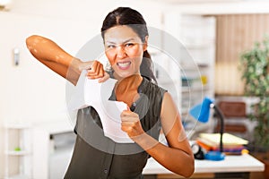 Desperate aggressive business woman ripping paper documents in office