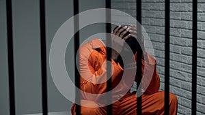 Desperate black prisoner sitting in cell, wrongly accused person, faulty system