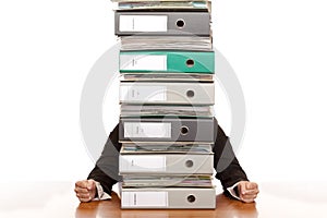 Desperate business woman sits behind folder stack