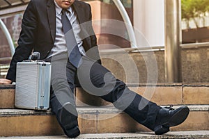 Desperate businessman sitting hopelessly on stair floor