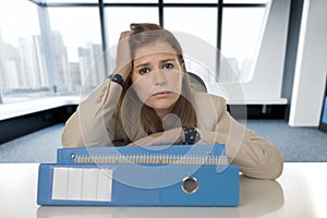 Desperate businesswoman suffering stress and headache at desk looking worried