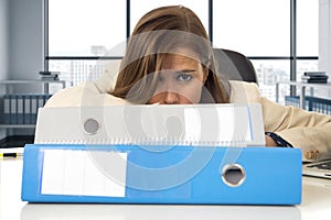 Desperate businesswoman suffering stress and headache at desk looking worried