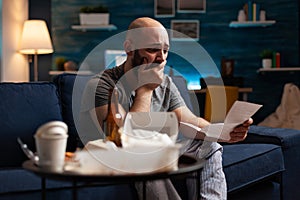 Desperate frustrated stressed young man reading letter, payment debt notification