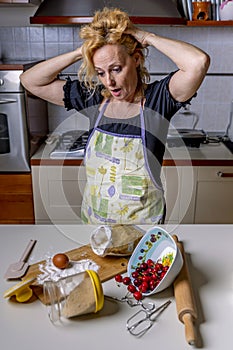 Desperate housewife with hands in her hair for the mess in the kitchen, which she will have to clean up