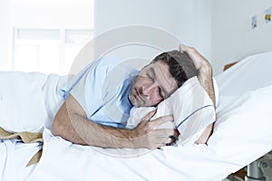 Desperate man at hospital bed alone sad and devastated suffering depression _