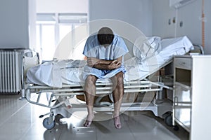 Desperate man sitting at hospital bed alone sad and devastated s